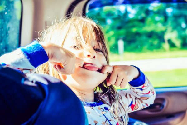 Kind zieht Grimassen im Auto