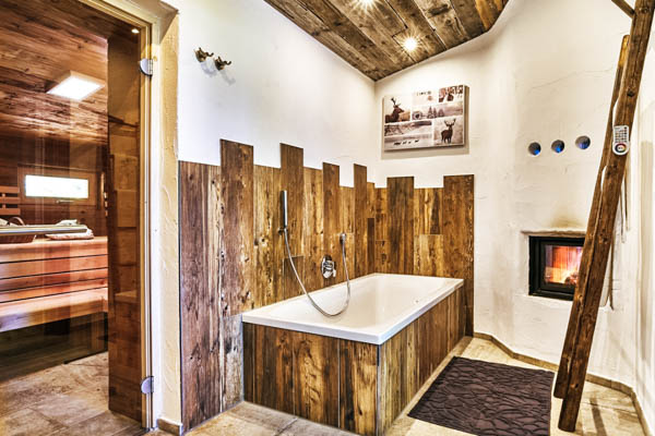 Bad mit Kamin und Blick in die Sauna in der Berghütte GLÜCKlich