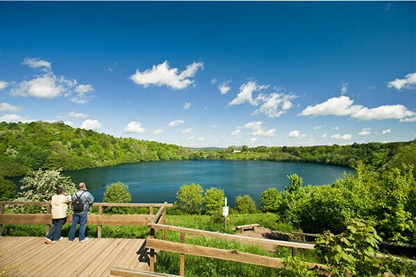 Blick auf das Weinfelder Maar Bei einem Spaziergang auf dem Uferweg entlang des Weinfelder Maares genießen Wanderer ein Heilklima mit frischer und sauberer Luft.