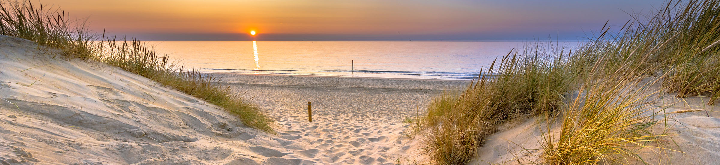 Dünen mit Blick auf Meer und Sonnenuntergang