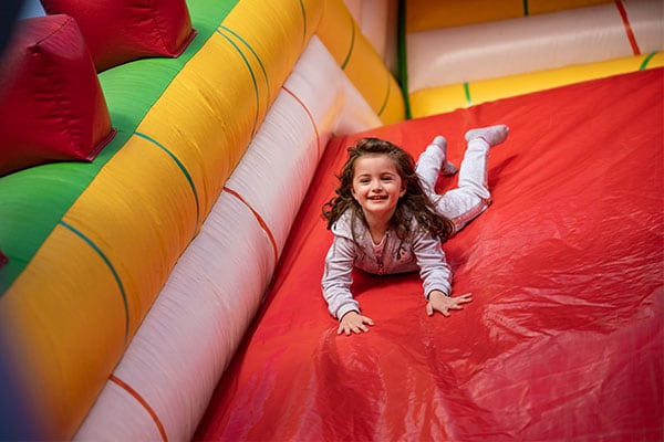 Mädchen rutscht auf Hüpfburg