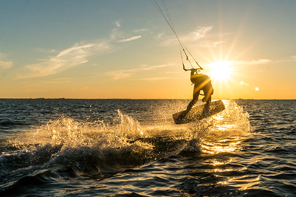Kitesurfer bei Sonnenuntergang auf Meer
