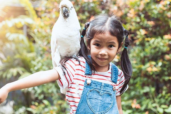 Mädchen mit Vogel auf dem Arm im Vogelpark Walsrode