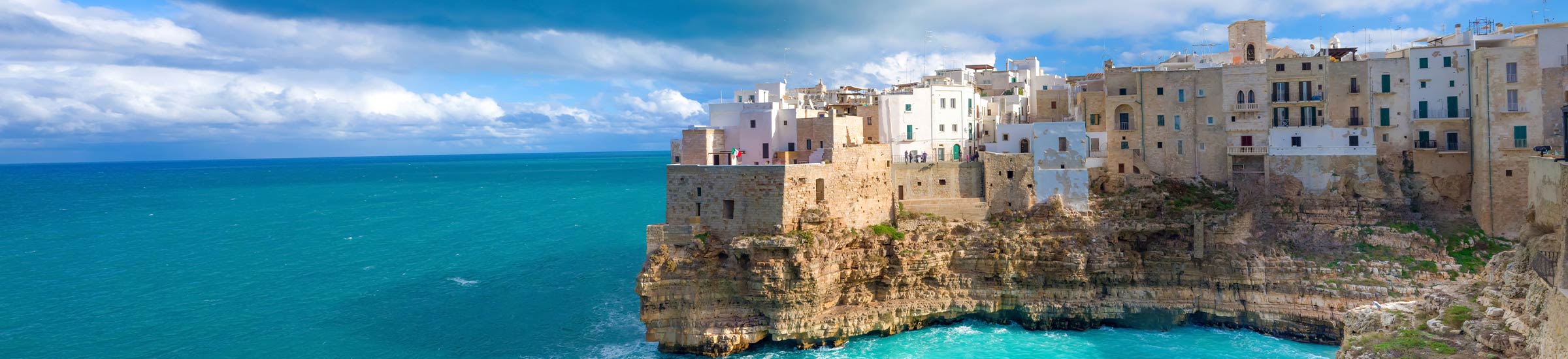 Bucht in Polignano a Mare mit weißen Häusern auf dem Felsen