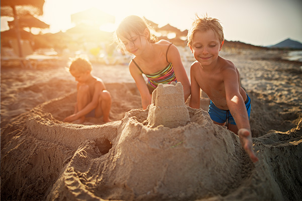 Kinder bauen eine Sandburg am Strand