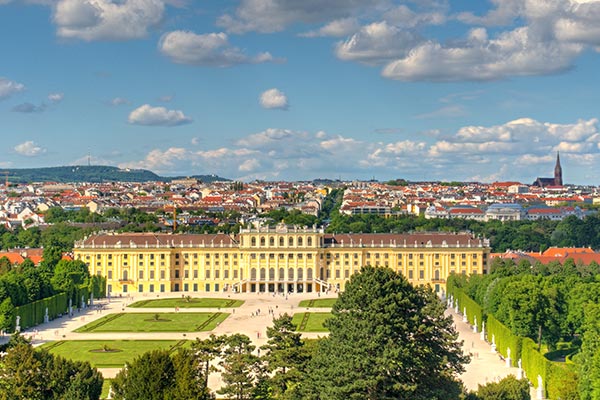 Gelbes Schloss Schönbrunn mit riesiger Gartenanlage vor den Gebäuden Wiens