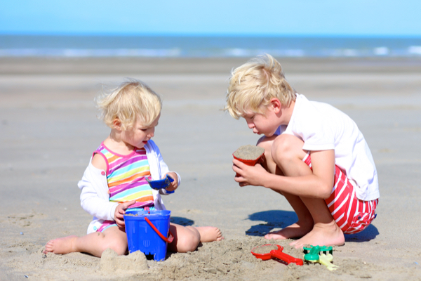 Kinder bauen Sandburgen am Strand