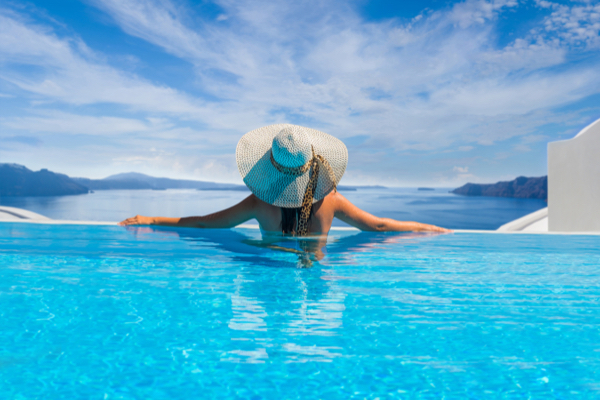 Frau genießt die Aussicht vom Pool auf Santorini in Griechenland
