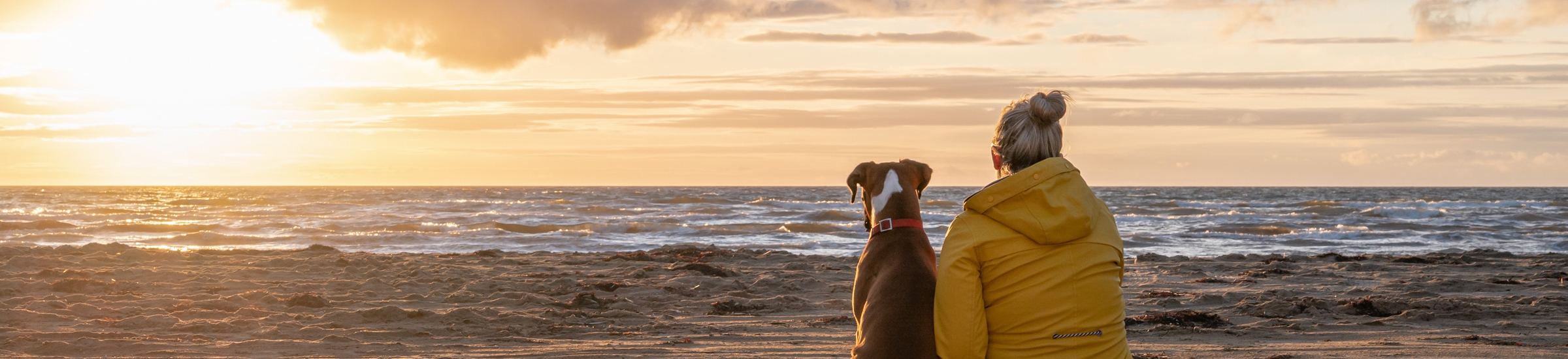 Frau mit Hund am Strand