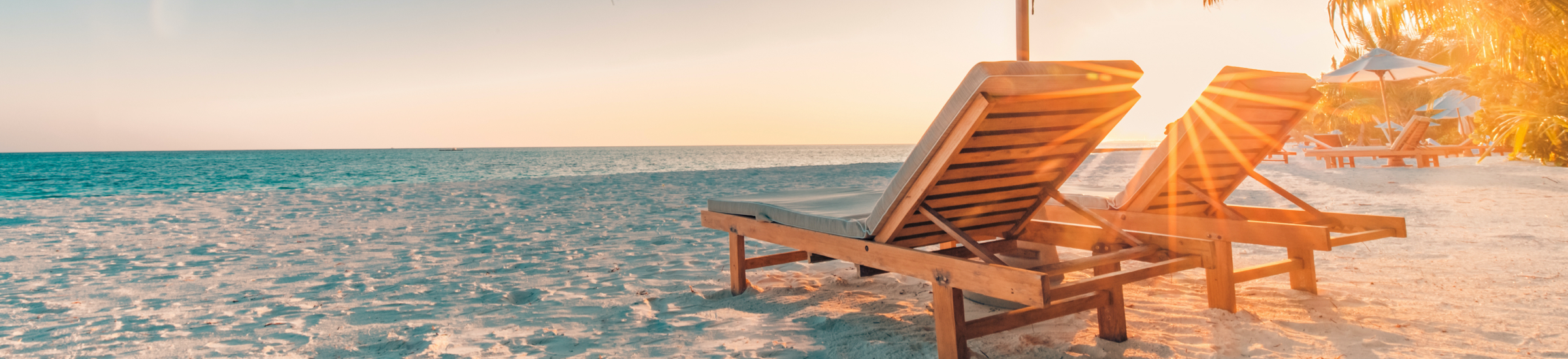 Liegestühle mit Sonnenschirm am Strand