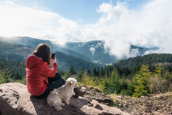 Frau mit Hund genießt den Ausblick im Schwarzwald
