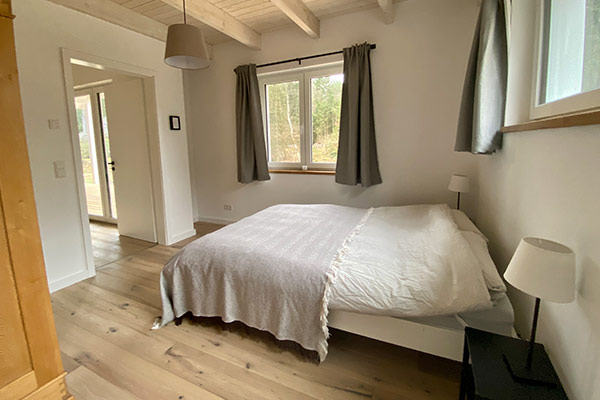 Ein Schlafzimmer mit Doppelbett im Ferienhaus "the forest"